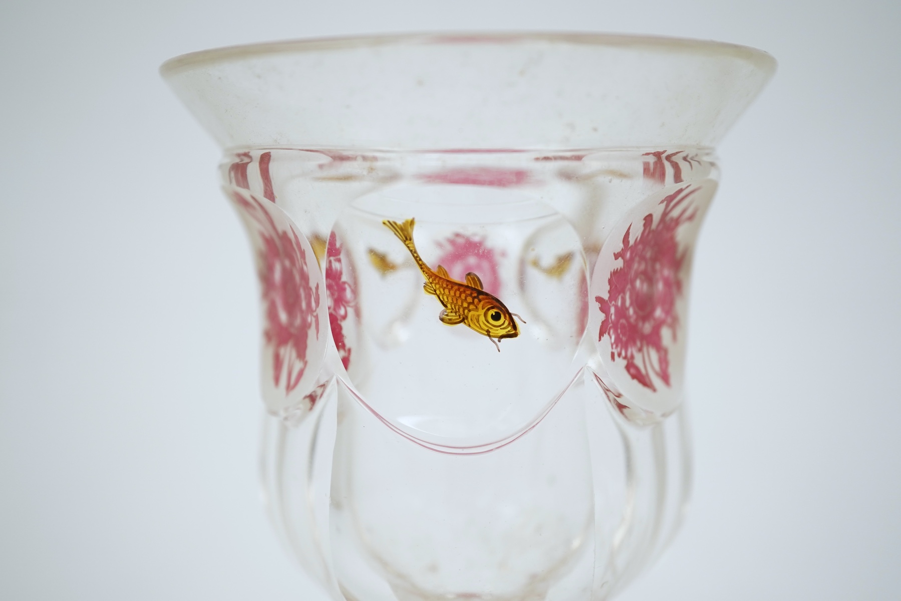Two Bohemian transparent enamelled ‘fish’ beakers, and a similar faceted goblet, c.1840-60